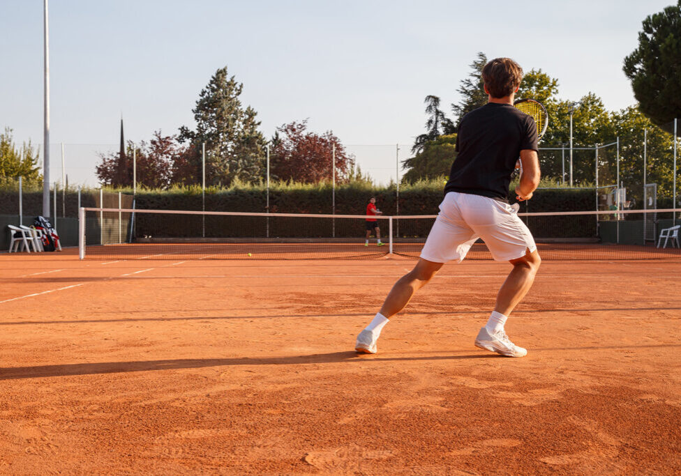 Professional tennis player playing tennis on a clay tennis court