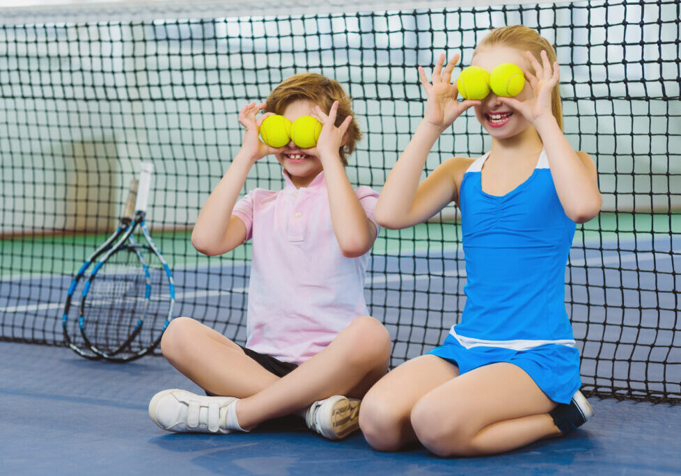 children having fun and playing on the tennis court