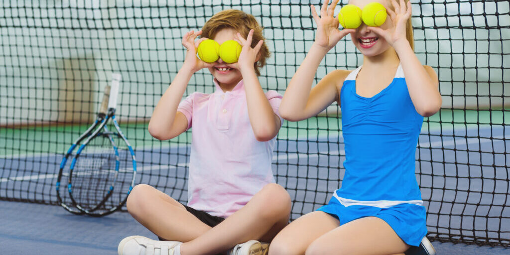 children having fun and playing on the tennis court
